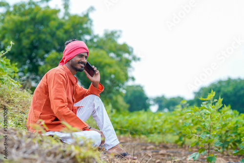 Indian farmer talking on smartphone at agriculture field. © PRASANNAPIX
