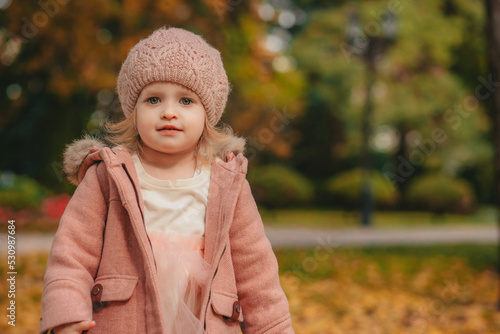 little girl playing in autumn park