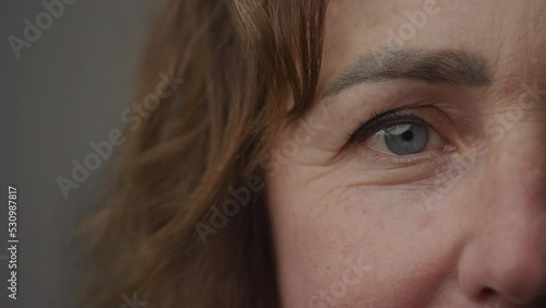 Close up of caucasian senior woman blue eye looking at camera and blinking