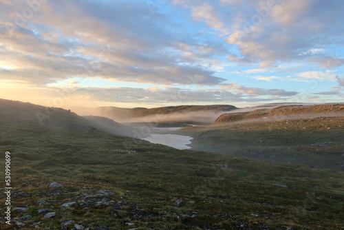 Foggy landscape under the midnight sun in Norway