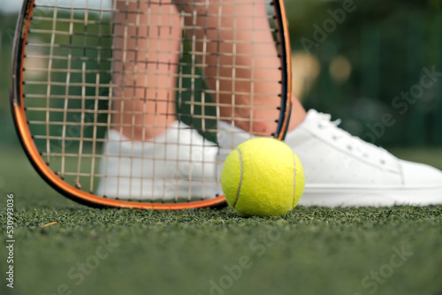 legs and tennis racket close-up. ball and racket on the tennis court.