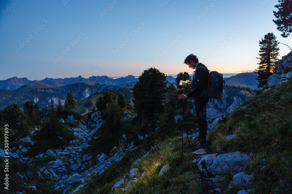 silhouette of hiker with headlamp at dusk in Naturpark Diemtigtal