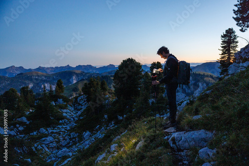 silhouette of hiker with headlamp at dusk in Naturpark Diemtigtal © schame87