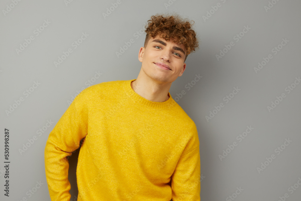 a brightly dressed man stands on a gray background and, squinting his eyes with pleasure, leans forward to the camera in a relaxed pose. Photo for inserting an advertising layout a brightly dressed man stands on a gray background and, squinting his eyes with pleasure, leans forward to the camera in a relaxed pose. Photo for inserting an advertising layout