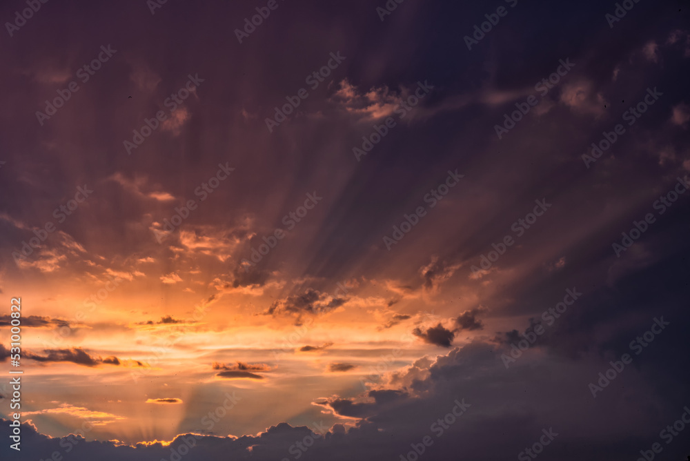 Beautiful sun beams in a sky over dramatic stormy clouds