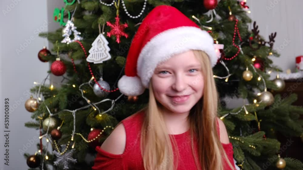 Little girl in red Santa's hat dancing. Smiling girl in red hat. Christmas and New Year concept Little girl in red Santa's hat dancing. Smiling girl in red hat. Christmas and New Year concept