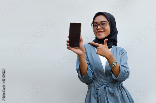 young Indonesian woman holding smartphone isolated on white background