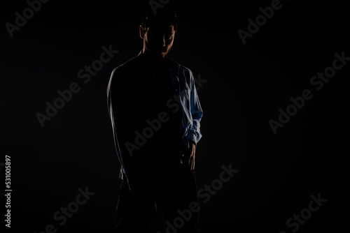 Male model posing in a light dimmed room