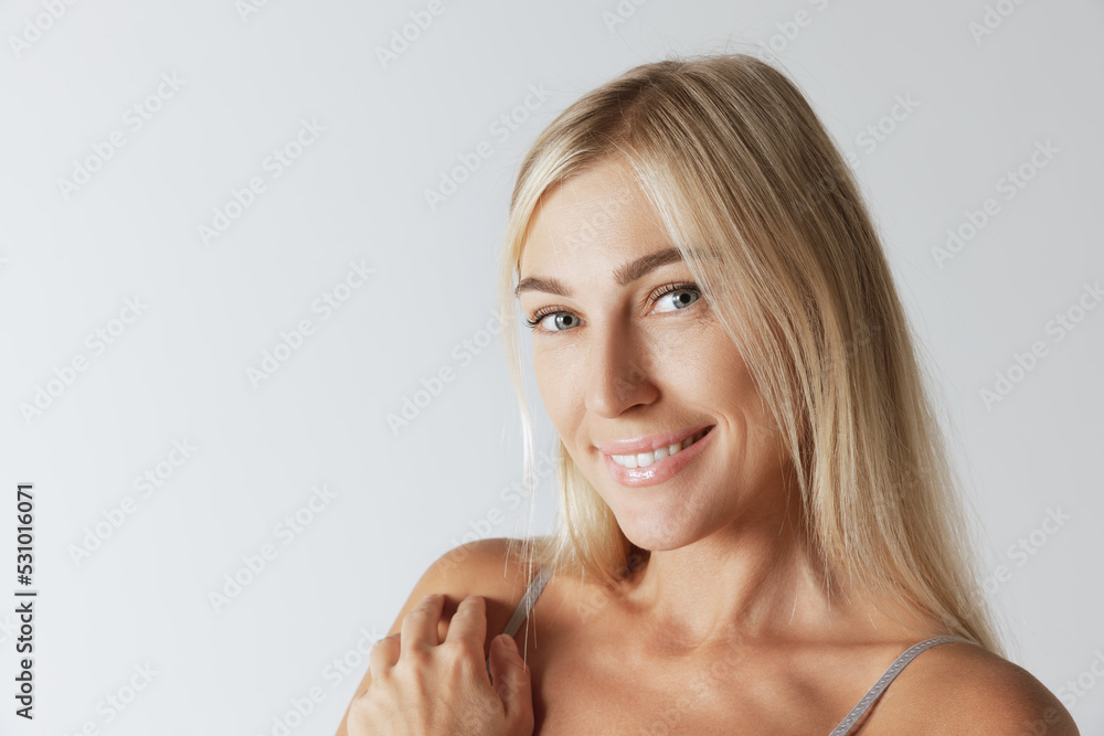Closeup portrait of young pretty woman with long blond hair smiling and looking at camera with happy and relaxed face expression Closeup portrait of young pretty woman with long blond hair smiling and looking at camera with happy and relaxed face expression