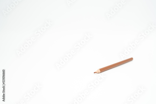 brown wooden colored pencil on a white background with a point (lead) in focus