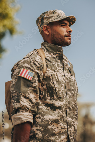 Fotografía Patriotic young soldier standing at attention outside his home
