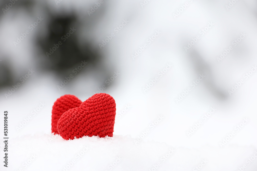 Love hearts, Valentine's card, two red knitted symbols of passion in the snow forest. Background for romantic event, Christmas celebration or winter weather Love hearts, Valentine's card, two red knitted symbols of passion in the snow forest. Background for romantic event, Christmas celebration or winter weather