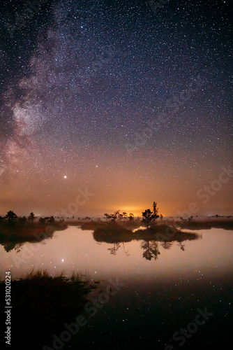 Milky Way Galaxy In Night Starry Sky Above Rural Landscape In Summer Season. Real Colorful Night Stars Above Swamp. Amazing Glowing Stars Effects Above Landscape. Natural Starry Sky Above Landscape.