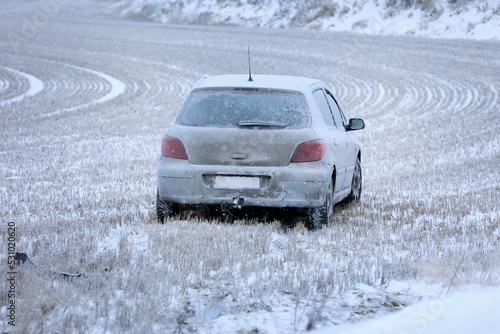 Wrecked Car Driven Off Slippery Road in Stubble Field on a Day of Winter. 