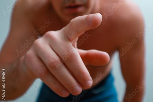 Undressed Man pressing buttons,close up finger. The concept of body language, expression of emotions, reaction. Young angry naked man pointing finger to camera
