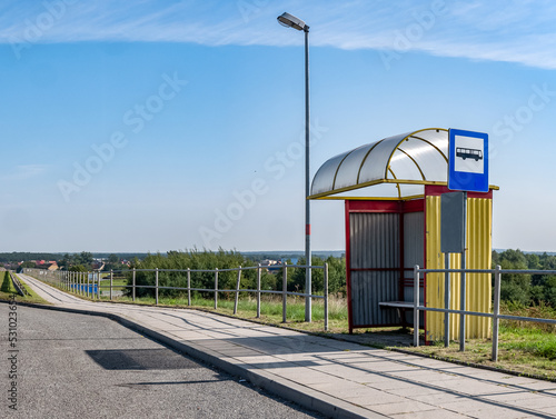 Żółto niebieski przystanek autobusowy stojący na odludziu po za obszarami wiejskimi o letniej porze w zachodniej Polsce