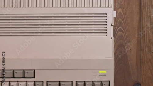 Top view of a hand inserting a floppy into a microcomputer and loading disk