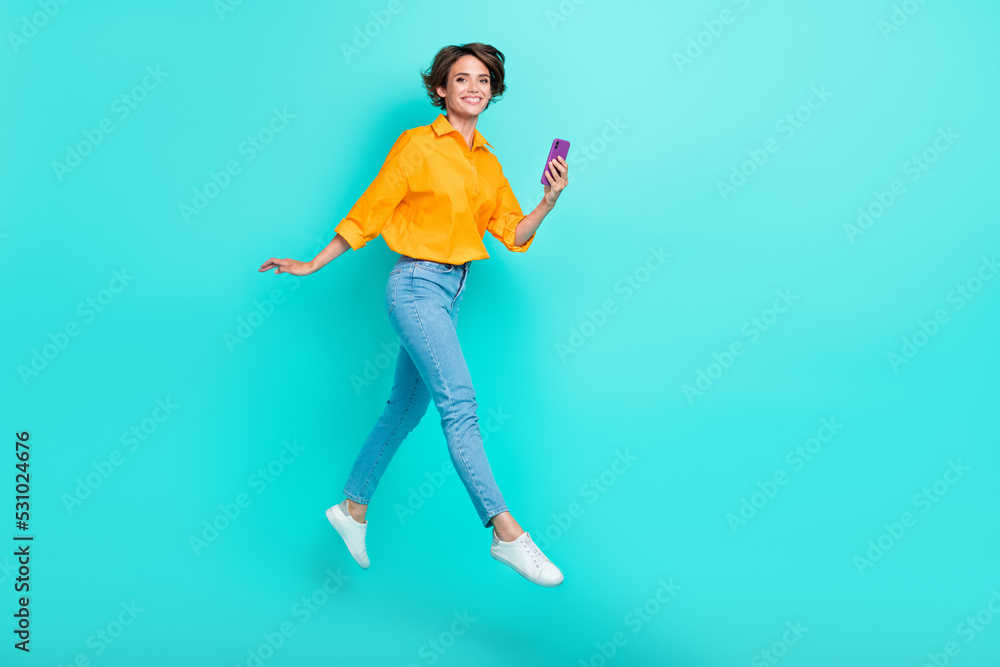 Full length photo of pretty lady enjoy rejoice opportunity remote study work telephone device empty space isolated on cyan color background Full length photo of pretty lady enjoy rejoice opportunity remote study work telephone device empty space isolated on cyan color background