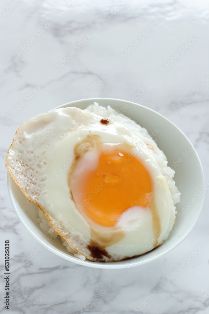 Sunny side up fried egg on rice with soy sauce for Asian breakfast food Sunny side up fried egg on rice with soy sauce for Asian breakfast food