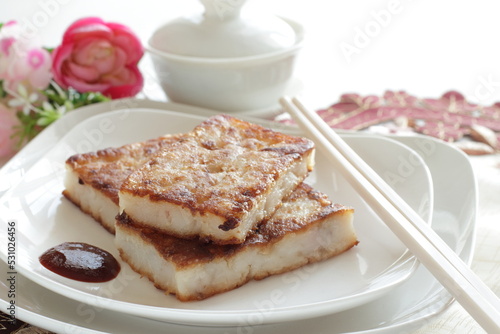 Chinese food  Pan fried radish cake on dish with sweet chili sauce for yum cha food image