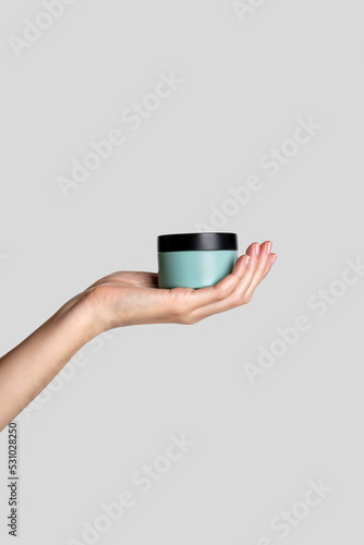 Woman hand showing cream product. Cosmetic product branding mockup. Daily skincare and body care routine. Female hand holding  cosmetic product mockup, close up.