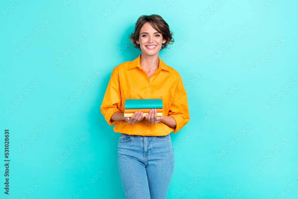 Portrait photo of young adorable gorgeous student woman hold many book wear smart casual clothes positive toothy smile isolated on aquamarine color background Portrait photo of young adorable gorgeous student woman hold many book wear smart casual clothes positive toothy smile isolated on aquamarine color background