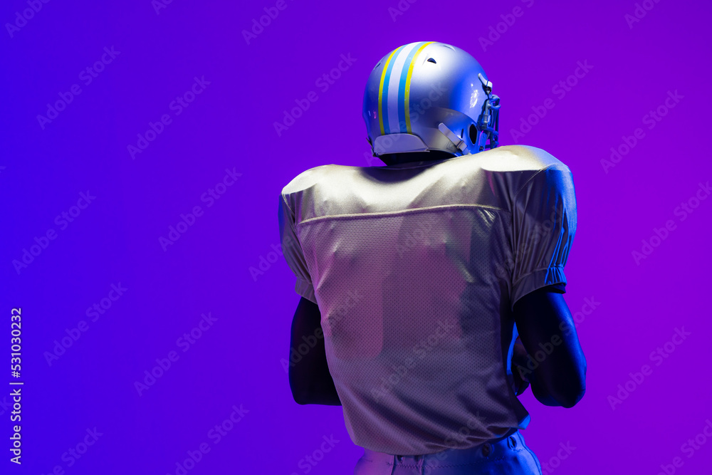 African american male american football player wearing helmet with neon blue lighting African american male american football player wearing helmet with neon blue lighting