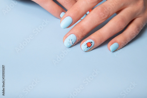 Female hands with winter snow manicure with stickers under a matte top