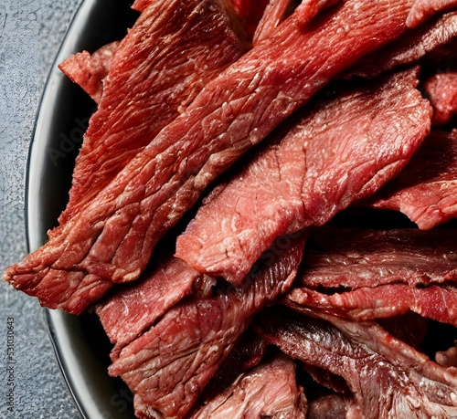 Bilde på lerret Closeup of beef jerky pieces on black plate