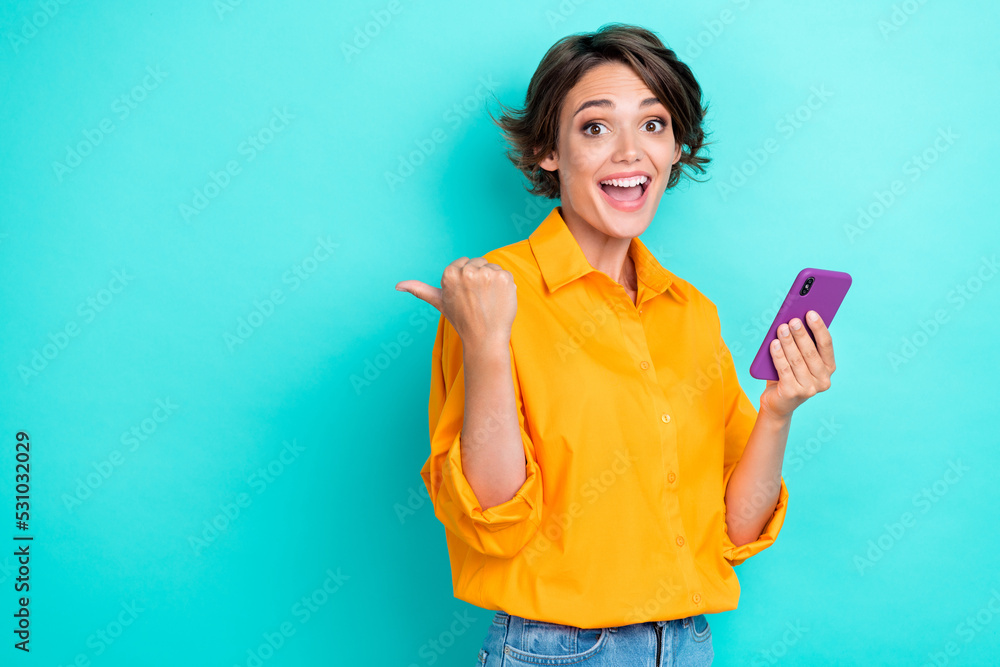 Photo of satisfied impressed lady hand hold modern telephone arm finger point demonstrate empty space isolated on cyan color background Photo of satisfied impressed lady hand hold modern telephone arm finger point demonstrate empty space isolated on cyan color background