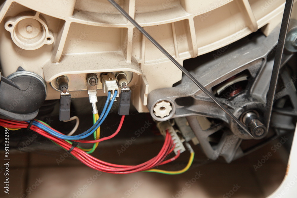 Heating element pins and electric motor with belt . Front load washing machine repair StockFoto