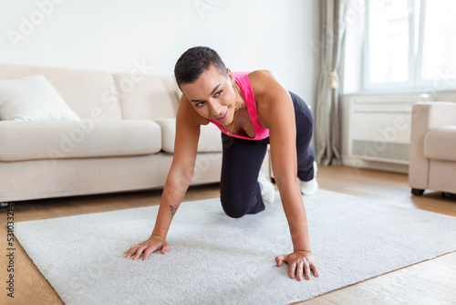 Workout Routine. Fit active athletic black woman doing mountain climbers exercise on yoga mat, strong sporty female in sportswear training abs core muscles in gym, fitness studio or at home
