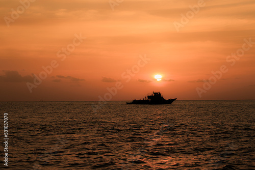 Sunset directly over a yacht in the Indian ocean