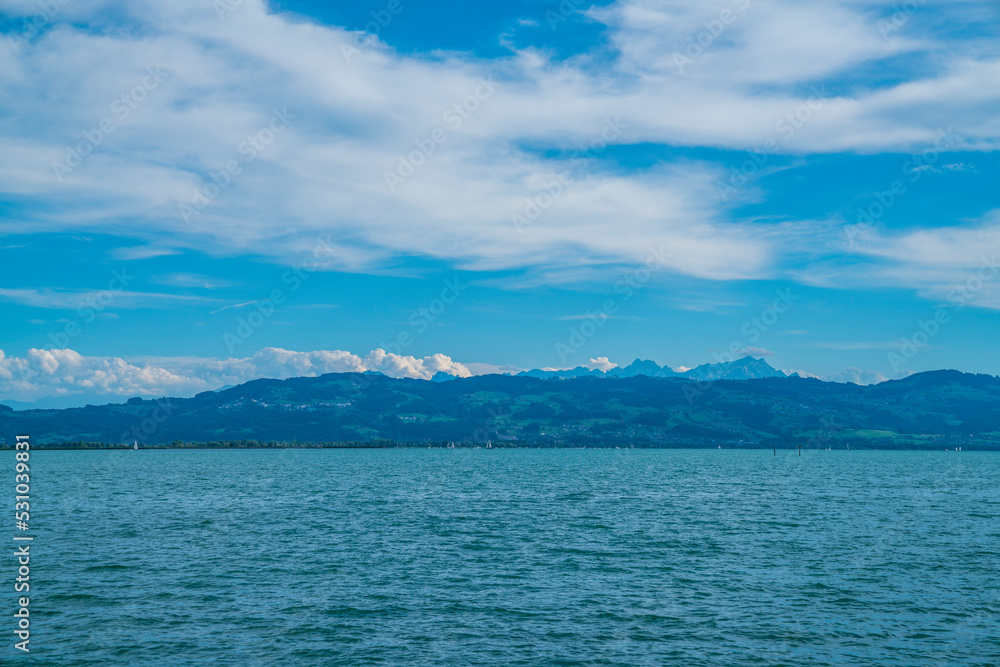 Germany, Bodensee lake water nature landscape panorama view to switzerland and alps mountains and saentis summit at sunset in summer