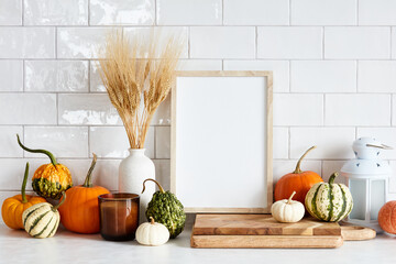 Autumn still life. Picture frame template, harvest of pumpkins, dry wheat on white table in scandinavian kitchen interior. Autumn fall, Harvest, Thanksgiving holiday concept.