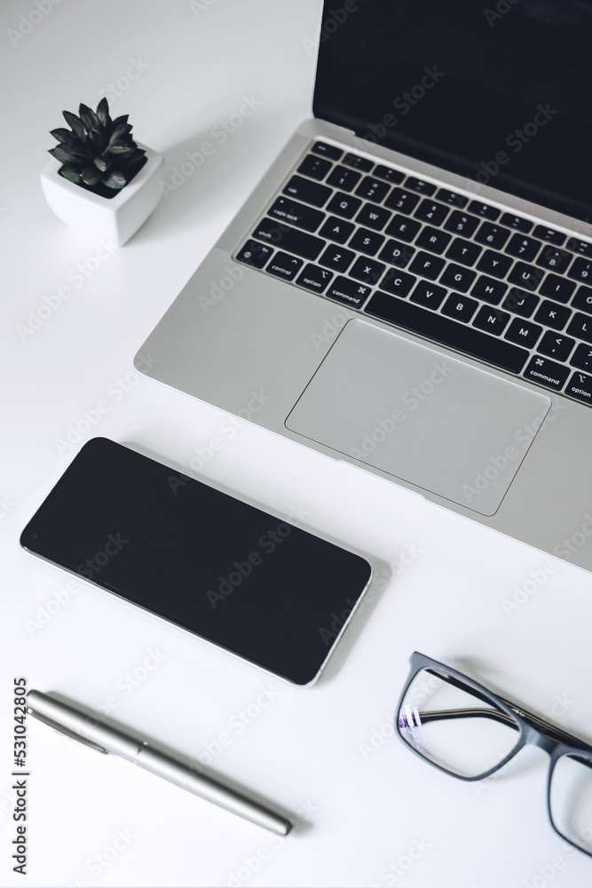 Digital business ideas. Online Business. Modern workspace with blank screen laptop, cell phone, pencil, on white work table Digital business ideas. Online Business. Modern workspace with blank screen laptop, cell phone, pencil, on white work table