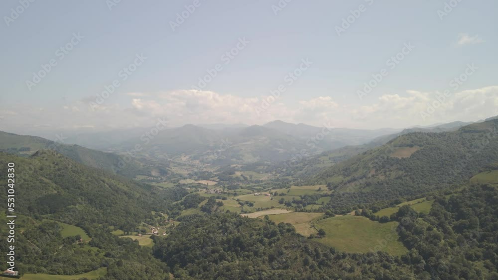 Flying over the pasturage hills and mountains in Basque Country, view of a village Flying over the pasturage hills and mountains in Basque Country, view of a village