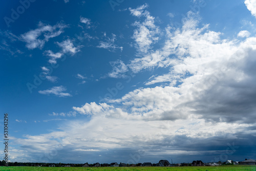 Photo of the clear blue sky with white clouds above countryside © Anton Tolmachov