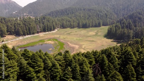 Khajjiar Lake in Chamba district of Himachal Pradesh, India. It is at a height of around 1,951 m above sea level between Dalhousie and Chamba Town.h uge grassy landscape, with evergreen cedar trees. photo