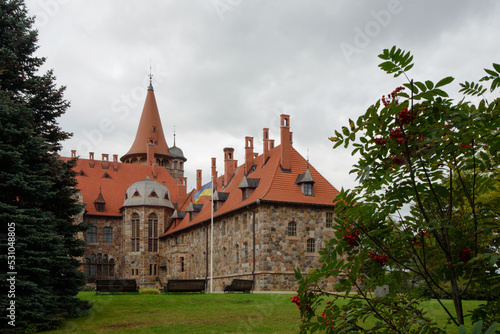 .a beautiful castle wall with a flying flag and an orange-red roof on a cloudy autumn day
