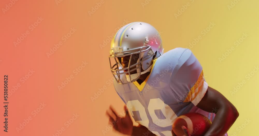 Video of african american american football player with ball over yellow to orange background Video of african american american football player with ball over yellow to orange background
