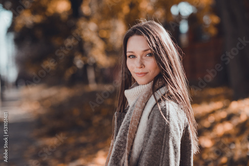 Profile photo of nice brown hairdo young lady walk in park wear coat scarf at the street in fall