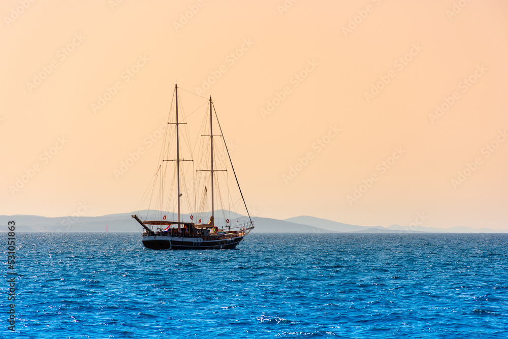 Lonely sailboat sails on the sea at dawn, beautiful landscape Lonely sailboat sails on the sea at dawn, beautiful landscape