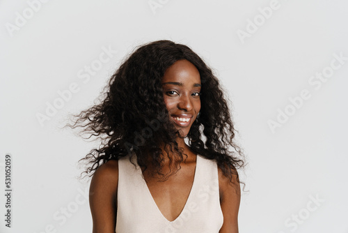 Young beautiful attractive long-haired smiling african woman looking at camera