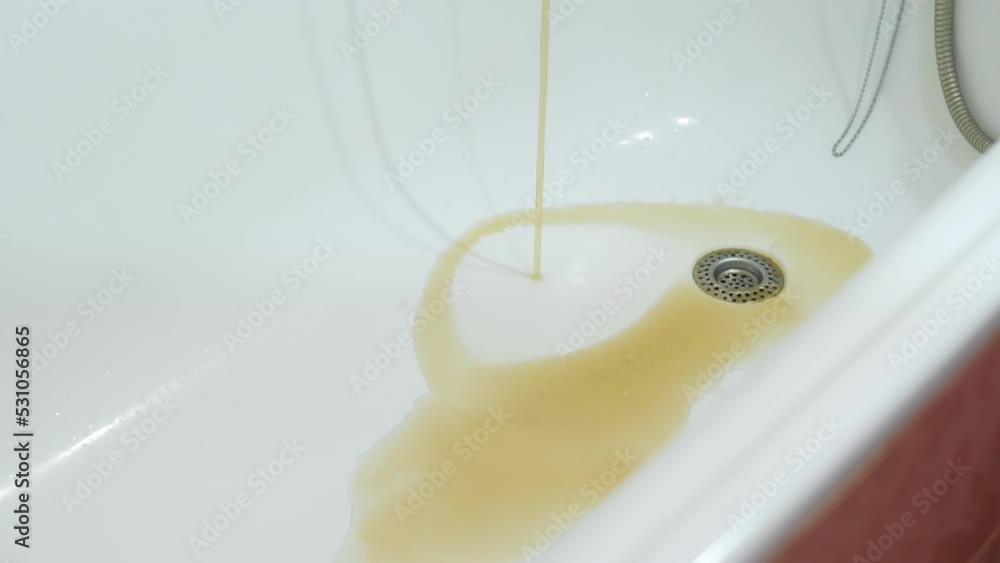 Rusty water running from the tap in a bath. Hazardous tap water flows in bathroom. Terrible rusty water. Unfit for drinking water pipes. Sewer drain. Sewerage. Environmental pollution concept. Rusty water running from the tap in a bath. Hazardous tap water flows in bathroom. Terrible rusty water. Unfit for drinking water pipes. Sewer drain. Sewerage. Environmental pollution concept.