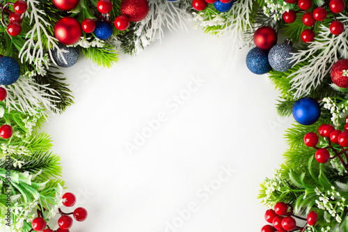 Fir branches and Christmas decor in red and blue colors on a white background with space for writing text.