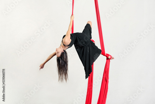 Female aerialist performing trick on aerial silks