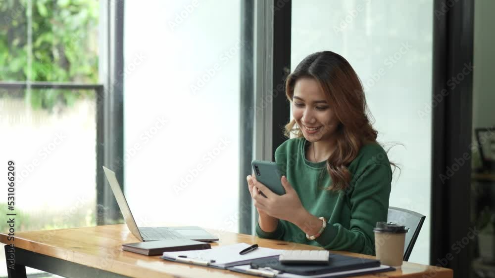 Asian businesswoman in formal suit in office happy and cheerful during using smartphone and working. Asian businesswoman in formal suit in office happy and cheerful during using smartphone and working.