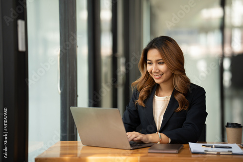 Asian woman working with laptop in her office. business financial concept.