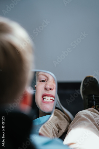 Young boy looking to the mirror in dentistry